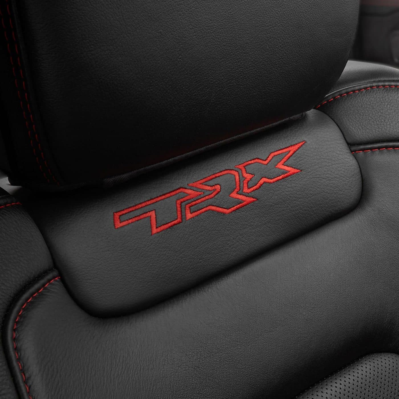 A close-up shot of the embroidered TRX logo on the front passenger seatback in the 2021 Ram 1500 TRX.